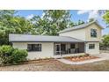 Charming two-story home featuring a cozy screened-in porch, complemented by lovely landscaping and mature trees at 1225 15Th St, Palm Harbor, FL 34683