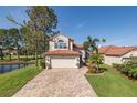 Charming home with a red tile roof, meticulously maintained lawn, and a brick driveway at 1228 Dartford Dr, Tarpon Springs, FL 34688