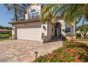 Well-maintained two-story home with a brick driveway and beautiful landscaping at 1228 Dartford Dr, Tarpon Springs, FL 34688