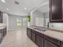 Eat-in kitchen featuring modern cabinets, stainless sink, tile flooring, and lots of natural light at 12713 Whitney Meadow Way, Riverview, FL 33578