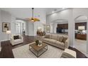 Open-concept living room featuring wood floors, neutral paint, elegant archways, and views of the dining room and kitchen at 12713 Whitney Meadow Way, Riverview, FL 33578