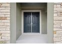 Elegant double front doors framed by stone pillars and lush landscaping at 13137 Wellspring Dr, Lithia, FL 33547