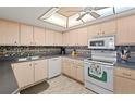 Kitchen featuring tile backsplash, white appliances and wood-look floors at 13440 Gulf Blvd # 501, Madeira Beach, FL 33708