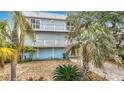Waterfront home boasts dual balconies, tropical landscaping, and a large garage with outdoor access at 13918 Raie Ave, Hudson, FL 34667