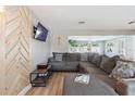 Spacious living room with large sofa, modern wood accent wall, and view to the dining room at 1503 4Th St Sw, Largo, FL 33770