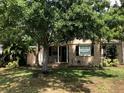 View of home featuring a covered front porch, dark shutters and mature trees at 1508 S Clark Ave, Tampa, FL 33629