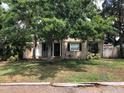 This single-story home features a covered front porch, dark shutters and mature trees at 1508 S Clark Ave, Tampa, FL 33629