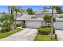 Beautiful townhouse showcasing lush landscaping and an attached two-car garage at 1628 Lullwater Ln, Lutz, FL 33549