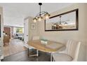Cozy dining room with stylish light fixture, neutral walls, decorative mirror, and access to the living room at 1726 York S St, Gulfport, FL 33707