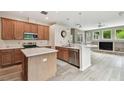 Modern kitchen with wooden cabinetry, quartz countertops, stainless steel appliances, and an island at 19106 Beckett Dr, Odessa, FL 33556
