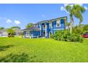 Bright blue home with manicured lawn and lush landscaping on a sunny day at 19620 Eagle Crest Dr, Lutz, FL 33549