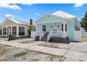 Side view of a charming bungalow with light blue exterior, white trim, and inviting front porch at 2306 W Ivy St, Tampa, FL 33607