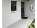 Exterior entrance with a door, a window with blinds, and a fire extinguisher box at 2650 Countryside Blvd # C106, Clearwater, FL 33761
