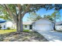 Charming one-story home with a well-manicured lawn and mature tree at 2707 Lakeville Dr, Tampa, FL 33618