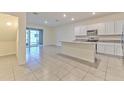 Open-concept kitchen with an island, stainless steel appliances, and tile flooring at 2882 Peony Prairie Ln, Wesley Chapel, FL 33543