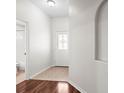 Bright hallway with tile flooring, decorative archway, and a clear view of the front door at 30901 Prout Ct, Wesley Chapel, FL 33543
