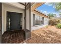 Inviting home entrance featuring a screen door, dark front door, and adjacent window with shutters at 3230 Player Dr, New Port Richey, FL 34655