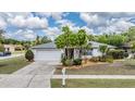 Well-maintained single-Gathering home with lush front yard landscaping and a pristine driveway leading to a two-car garage at 3230 Player Dr, New Port Richey, FL 34655