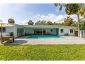 A backyard swimming pool with brick pavers, poolside seating, and a covered patio at 3236 San Pedro St, Clearwater, FL 33759