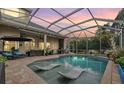 Inviting screened-in pool area with comfortable lounge seating, a grill, and a beautiful backyard at 3727 Janus Way, Palm Harbor, FL 34685