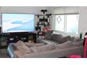 Comfortable living room with a plush gray couch, large window and modern entertainment setup, perfect for relaxing at 4928 Lake Ridge Ln, Holiday, FL 34690