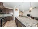Modern kitchen with an island, granite countertops, stainless steel appliances, and dark wood cabinets at 5225 5Th N Way, St Petersburg, FL 33703
