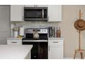 Modern kitchen boasts stainless steel appliances, white cabinetry, and stylish countertop decor at 616 11Th Nw St, Largo, FL 33770