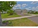 Charming home featuring a brick driveway, a 2-car garage, and a beautifully landscaped front yard at 7406 Parkshore Dr, Apollo Beach, FL 33572