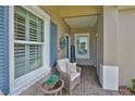 Inviting front porch with a cozy chair, side table, and 'Welcome' sign, enhancing the home's curb appeal at 7406 Parkshore Dr, Apollo Beach, FL 33572