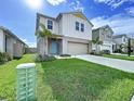 Beautiful two-story home with a well-manicured lawn and a charming light blue front door at 7554 Wallflower Trl, Wesley Chapel, FL 33545