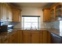 Bright kitchen features a window over the sink, stainless steel appliances, and oak cabinetry at 8209 Chaucer Dr, Weeki Wachee, FL 34607