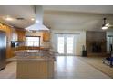 Open floorplan displaying the kitchen with an island cooktop and a cozy living room with a fireplace at 8209 Chaucer Dr, Weeki Wachee, FL 34607