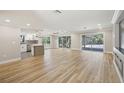 Bright, open living space with hardwood floors and sliders that lead to a screened in patio and pool at 911 S Florida Ave, Tarpon Springs, FL 34689