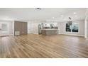 Open-concept living space with hardwood floors, stylish accents, and abundant natural light with kitchen view at 911 S Florida Ave, Tarpon Springs, FL 34689
