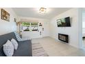 Comfortable living room featuring a modern fireplace and plenty of natural light at 11104 Taft Dr, Port Richey, FL 34668