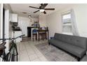 Open-concept living area featuring tile flooring, a ceiling fan, and a comfortable sofa, perfect for relaxing at 1142 7Th Nw St, Largo, FL 33770