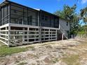 Rear exterior featuring white support beams, stairs leading up to the door and a fenced-in yard at 11729 John Robbins Rd, Riverview, FL 33578