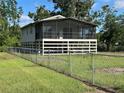 Elevated home featuring a screened porch and fenced yard, perfect for enjoying outdoor living at 11729 John Robbins Rd, Riverview, FL 33578