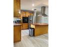 Well-equipped kitchen with stainless appliances, wood cabinets, and a center island at 13601 Audrey Ln, Largo, FL 33771