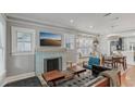 Bright and airy living room with hardwood floors, decorative fireplace, and large windows at 1402 E Powhatan Ave, Tampa, FL 33604