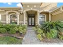 Charming front entrance with stone walkway, manicured landscaping, and covered entryway at 15104 Azra Dr, Odessa, FL 33556