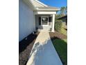 Inviting front porch area with a manicured lawn and walkway leading to the front door at 1600 Still River Dr, Venice, FL 34293