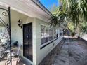 A quaint home exterior featuring a black door, multiple windows, and a cozy side patio area at 2221 York S St, Gulfport, FL 33707