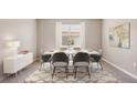 Bright dining room featuring a white table, modern chairs, stylish rug, and contemporary decor at 2245 Sienna Spruce St, Wesley Chapel, FL 33543
