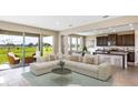 Open concept living room flowing into the kitchen with large windows providing natural light and outdoor views at 2245 Sienna Spruce St, Wesley Chapel, FL 33543