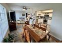 Open-concept living and dining area with a view of the modern kitchen, plus hardwood floors throughout at 2434 Australia E Way # 50, Clearwater, FL 33763