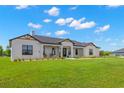 Eye-catching exterior with modern farmhouse appeal and an expansive green lawn at 3070 Smilodon Trl, Ruskin, FL 33570
