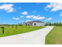 Spacious home featuring a long driveway and a well-maintained, sprawling green lawn at 3070 Smilodon Trl, Ruskin, FL 33570