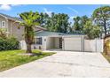 Beautiful single-story home with a well-manicured lawn, beautiful palm tree, and an attached garage at 3317 W Iowa Ave, Tampa, FL 33611