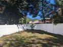 Spacious backyard featuring a pristine white fence and lush greenery, providing a private outdoor space at 3403 Jamais Wood Way, Tampa, FL 33618